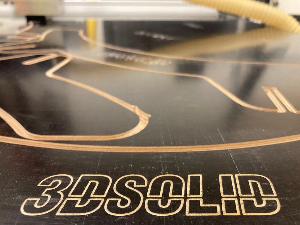Detail vyřezávaných a frézovaných dílů s označením 3DSOLID na pracovní ploše stroje